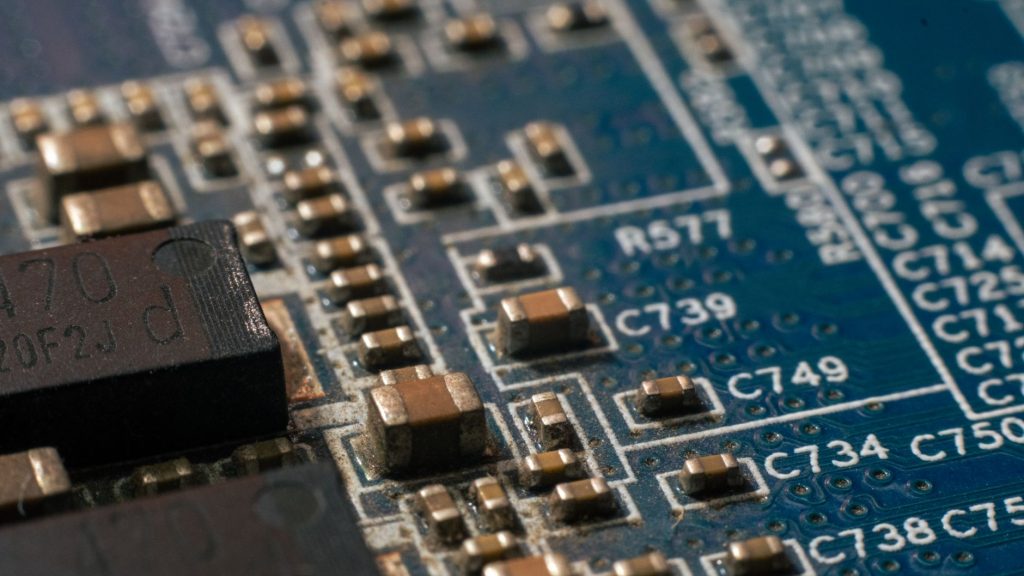 Close-up de uma placa de circuito com componentes eletrônicos e trilhas condutoras.