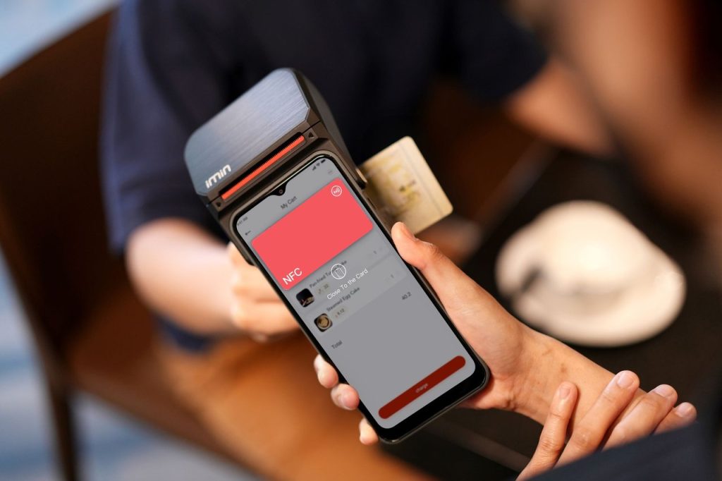 Pix por aproximação passa a permitir limites personalizados acima de R$ 500 Celular usando NFC para realizar um pagamento por aproximação em um terminal.